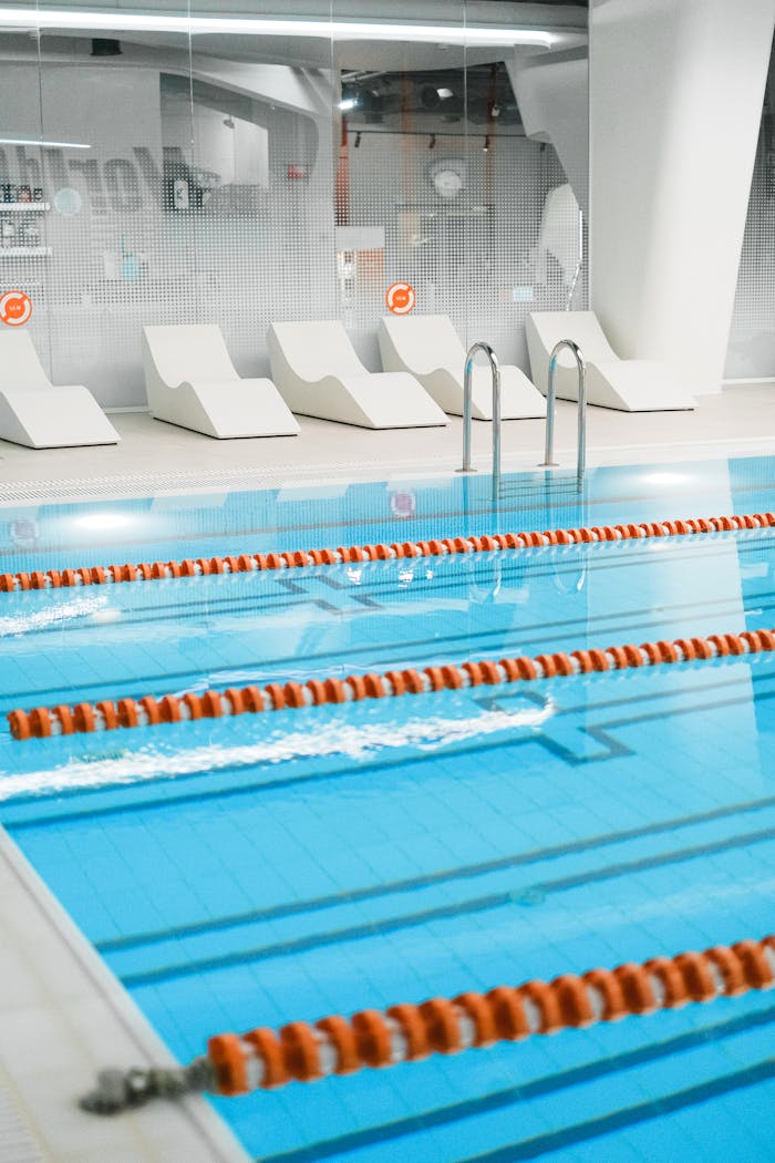 home-services-02 An elegant indoor swimming pool featuring lanes and stylish lounge chairs, ideal for relaxation and training.